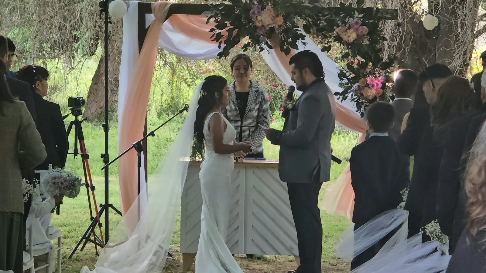 Ceremonia de matrimonio bajo pérgola en los jardines